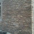 The exterior wall of a home outfitted with Charcoal Ledge stone veneer from Halquist's Ledge Collection.