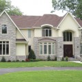 The exterior walls of a home outfitted with Chilton Ivory stone veneer from Halquist's Ledge Collection.