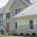 The exterior walls of a home outfitted with Tumbled Brookfield stone veneer from Halquist's Ledge Collection.